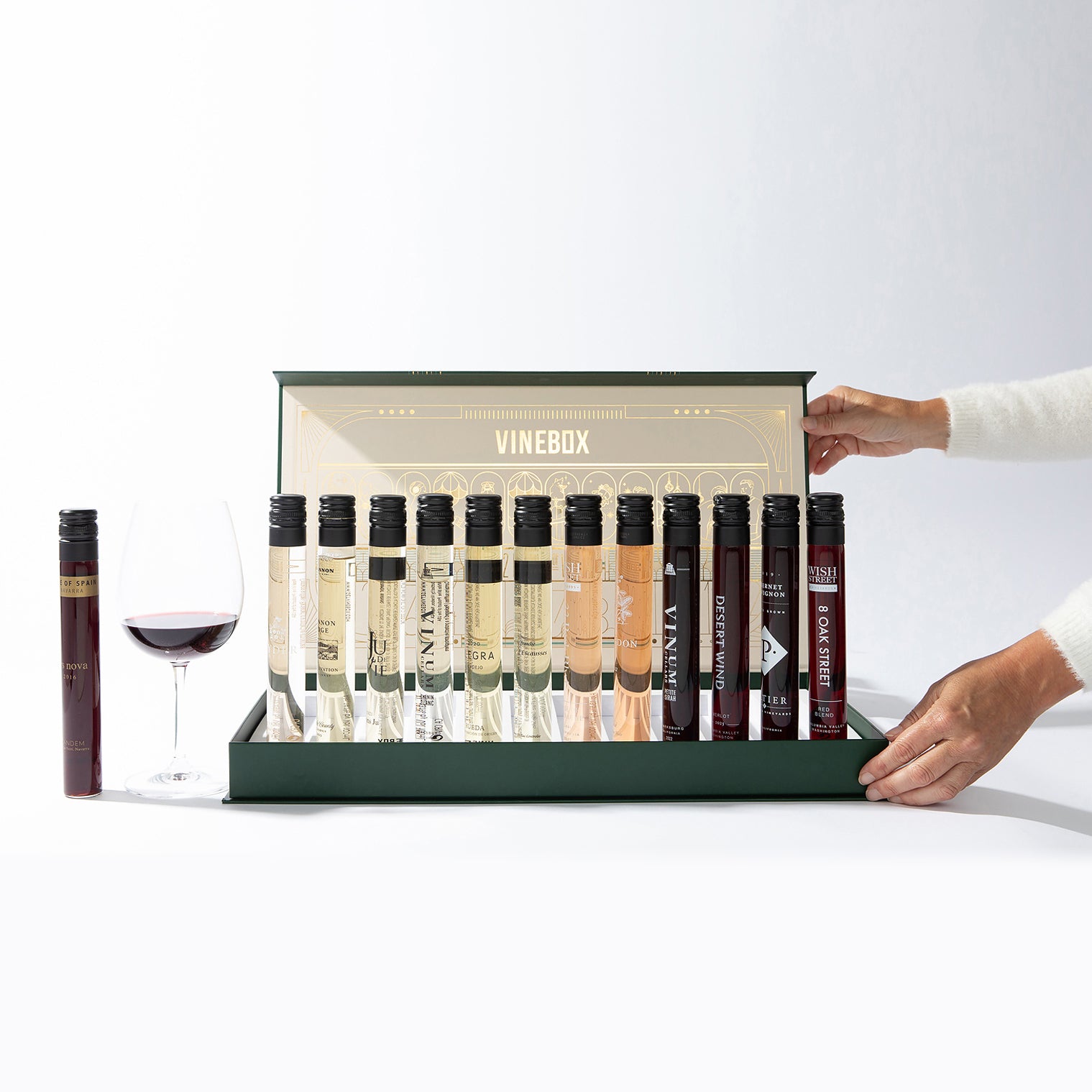 Vinebox wine tasting set with a hand opening the box on a white background