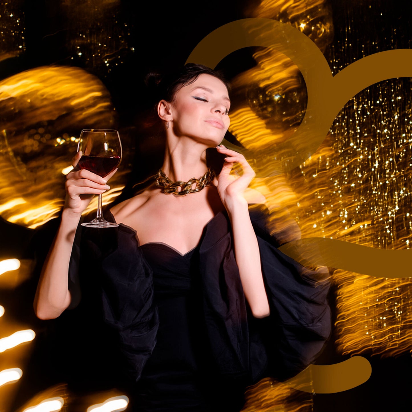 Woman in a black dress holding a glass of wine against a festive background with lights.