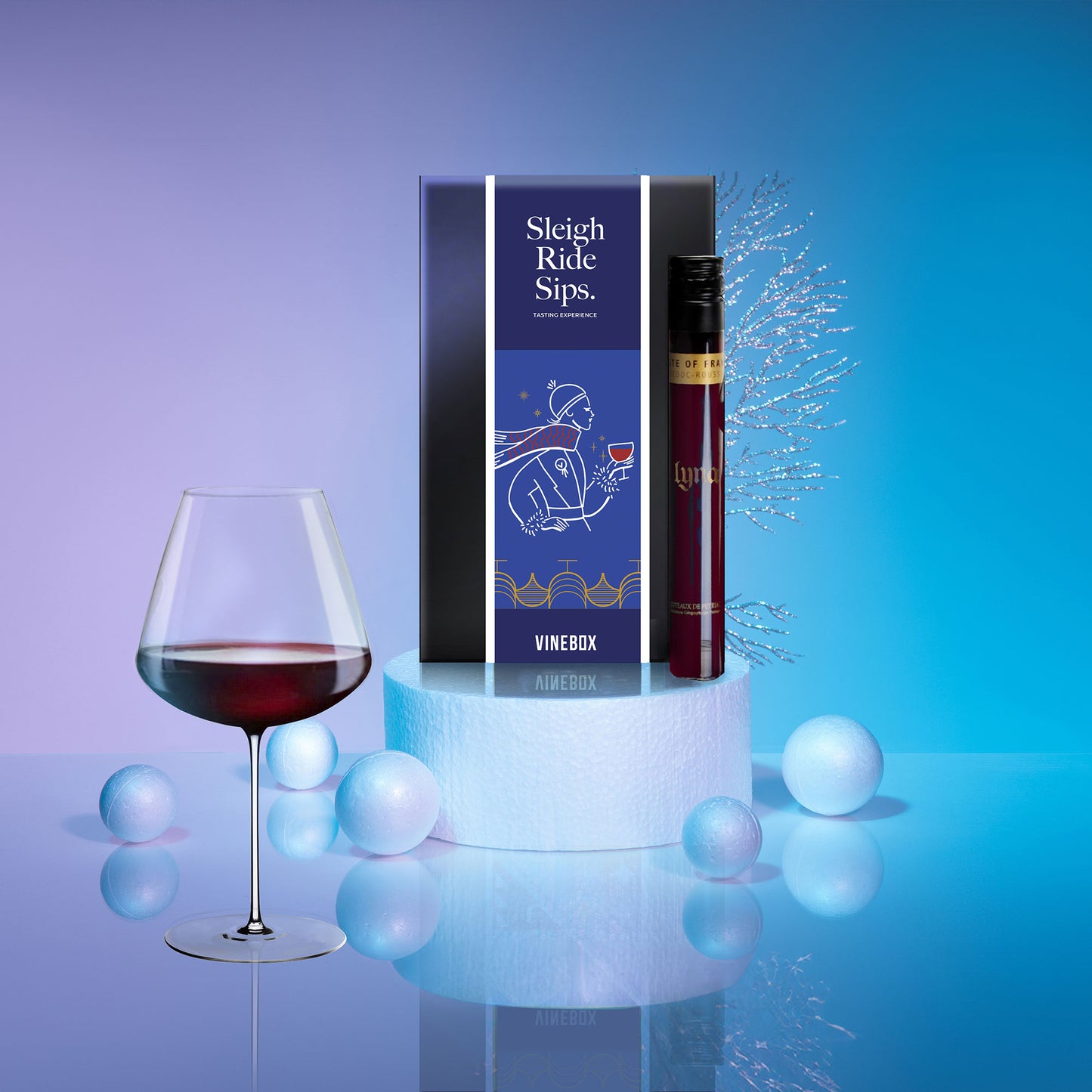 Wine bottle, glass, and box with 'Sleigh Ride Sips'