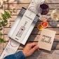 Vinebox Gratitude 9-wine tasting gift box with thank you theme 'Gratitude' card and a glass of wine on a wooden table.