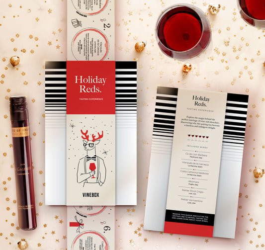 Vinebox holiday red wine tasting experience packaging with a glass of red wine on a decorative background.