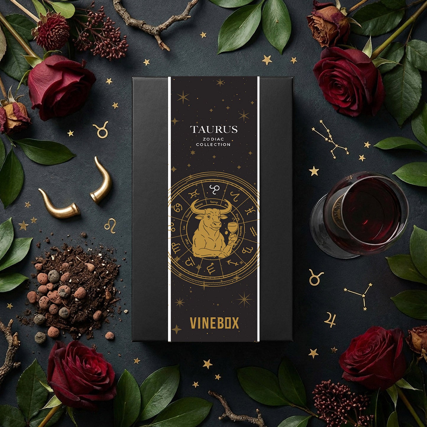 Vinebox Taurus Zodiac Collection box surrounded by red roses, leaves, and a glass of red wine on a dark background.